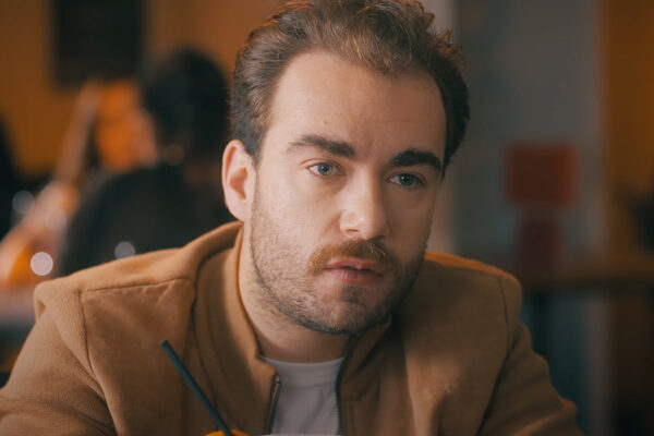 Marc (Lucas Baran) discute dans un bar.