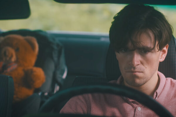 Gabriel (Loïs Vial) au volant, un ours en peluche sur le siège bébé.